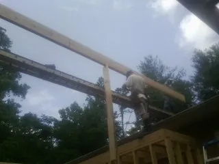Carpenter setting a ridge beam over a new addition frame — Ice Dam Removal by Roofing Brothers in Maquon