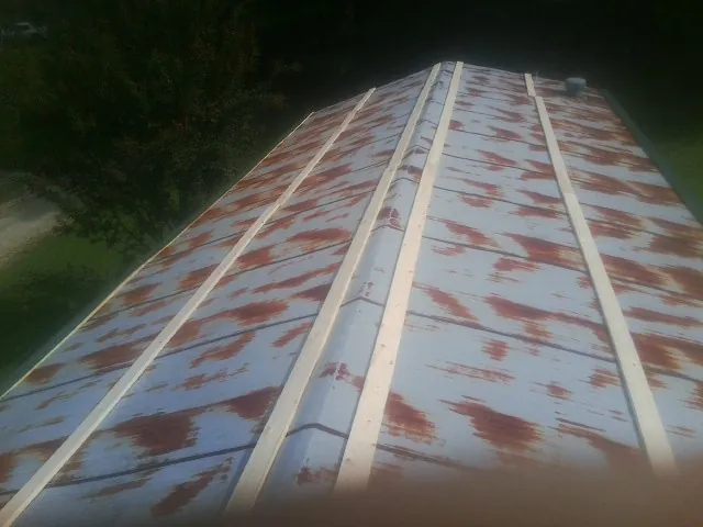 Rusted metal roof panels with new wood purlins before replacement — Storm Damage Roof Repair in Maquon by Roofing Brothers