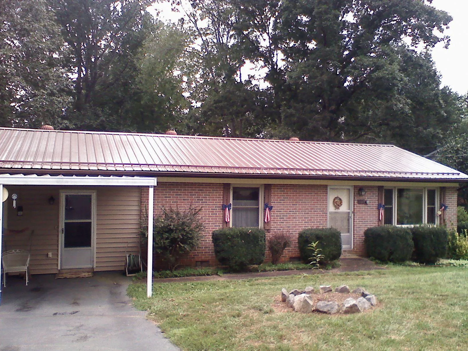 Bronze metal roof and carport on a brick ranch home — Roof Repair work by our crew in Maquon